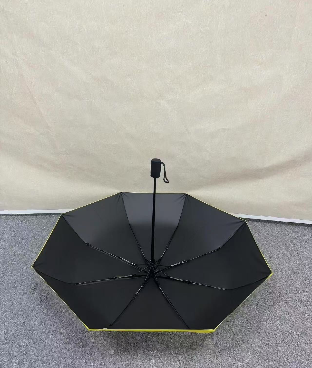 No Kings. Bright yellow protest umbrella with a picture of a black crown with a red X painted over the crown.