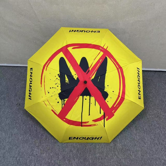 No Kings!  Bright yellow protest umbrella  with a picture of a black crown with a red X painted over the crown.