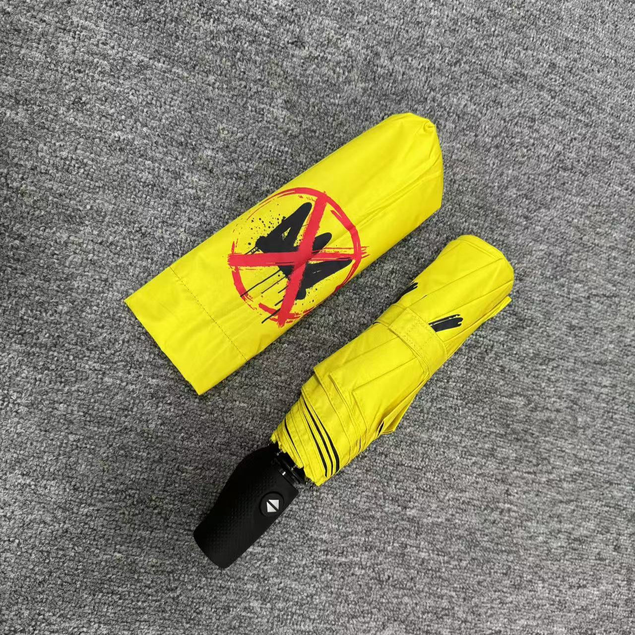 No Kings.  Bright yellow protest umbrella  with a picture of a black crown with a red X painted over the crown.