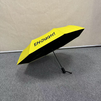 No Kings.  Bright yellow protest umbrella  with a picture of a black crown with a red X painted over the crown.