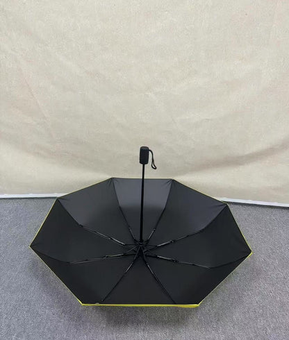 No Kings.  Bright yellow protest umbrella  with a picture of a black crown with a red X painted over the crown.